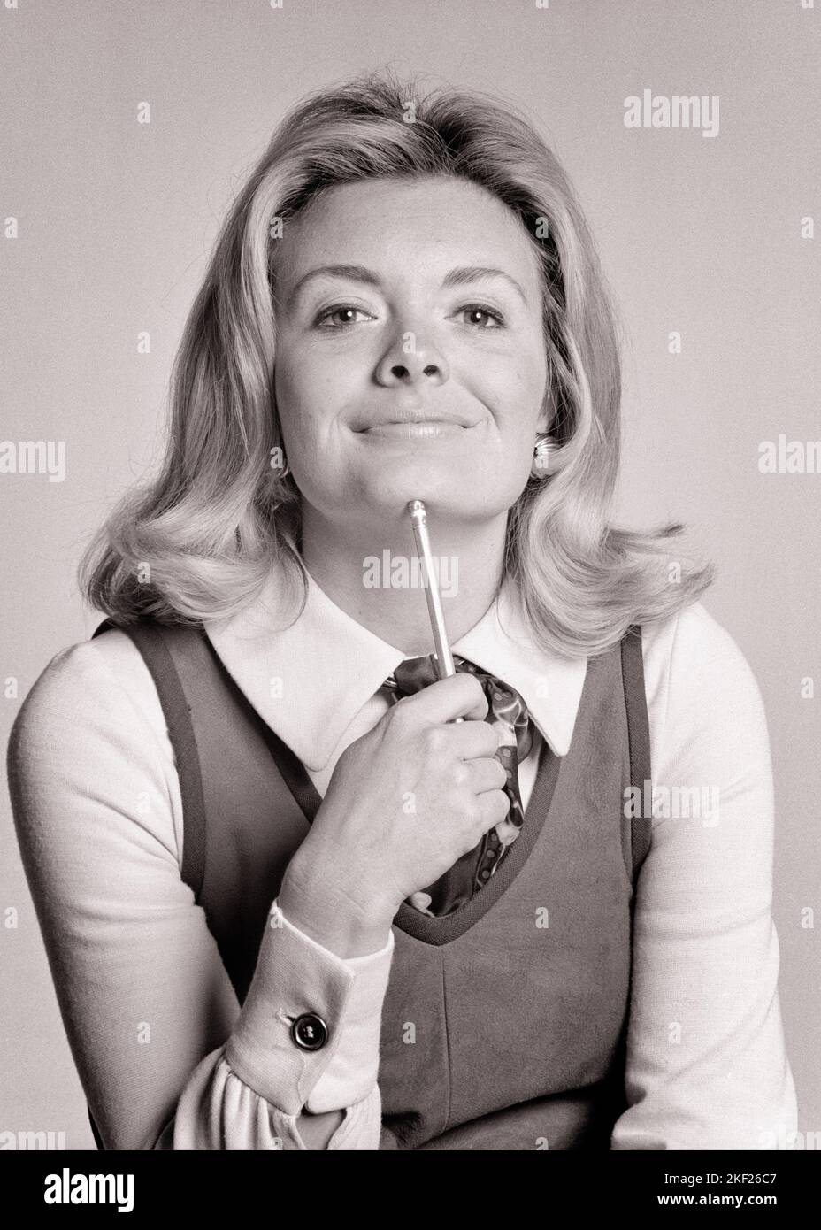 1970S PORTRAIT BLONDE FEMME TAPOTANT LE CRAYON À SON RCIP AVEC L'EXPRESSION SOURIANTE PENSIVE PORTANT LE PULL EN DAIM AVEC LE CHEMISIER - G8297 HAR001 HARS CLERK FEMMES EMPLOIS STUDIO SHOT MANAGER ESPACE DE COPIE DEMI-LONGUEUR FEMMES PERSONNES PENSIVE CHIN CONFIDENCE B&W CONTACT VISUEL PROFESSION BONHEUR COMPÉTENCES CAVALIER STRATÉGIE INSTRUCTEUR SAVOIR LEADERSHIP OFFICE TRAVAILLEUR OPPORTUNITÉ SUPERVISEUR AUTORITÉ CHEMISIER PROFESSIONS GAL VENDREDI ADMINISTRATEUR ÉDUCATEUR LONG HAIR SECRÉTAIRES TAPPING ÉLÉGANT AMANENSIS ÉDUCATEURS INSTRUCTEURS DIRECTEURS D'ÉCOLE MOYENNE-ADULTE ENSEIGNE LE DAIM NOIR ET BLANC CAUCASIEN L'ETHNIE CLÉRICALE Banque D'Images
