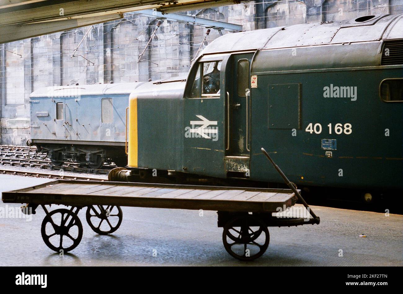 Le chemin de fer de style ancien - 40168 ex-Scottish Region Class 40 attend à la gare de Carlisle Citadel avec 1E23, le 10,40 à Leeds service - le conducteur appréciant une fumée calme. Pris le 21st juillet 1984. Banque D'Images