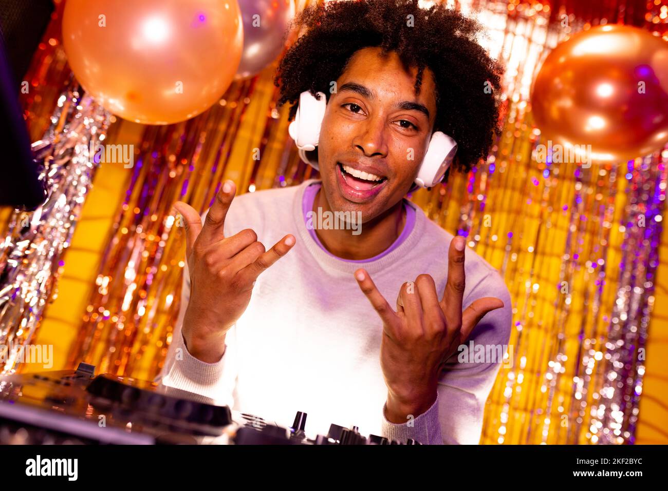 Portrait d'un DJ afro-américain souriant dans un casque jouant de la musique dans une boîte de nuit gestante Banque D'Images