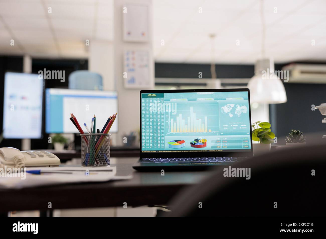 Logiciel d'analyse d'investissement boursier avec panneau de contrôle financier sur un ordinateur portable sur un bureau moderne. Lieu de travail sans que les employés travaillent avec un arrière-plan flou. Banque D'Images