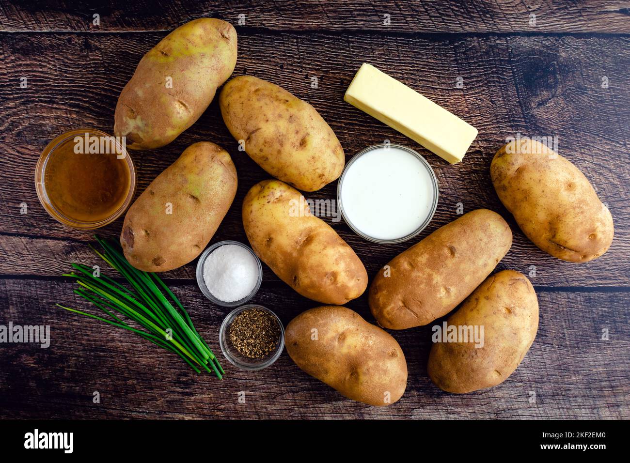 Ingrédients de pommes de terre écrasés sur une table rustique en bois : pommes de terre Russet, crème, beurre et autres ingrédients pour le plat de pommes de terre écrasé Banque D'Images
