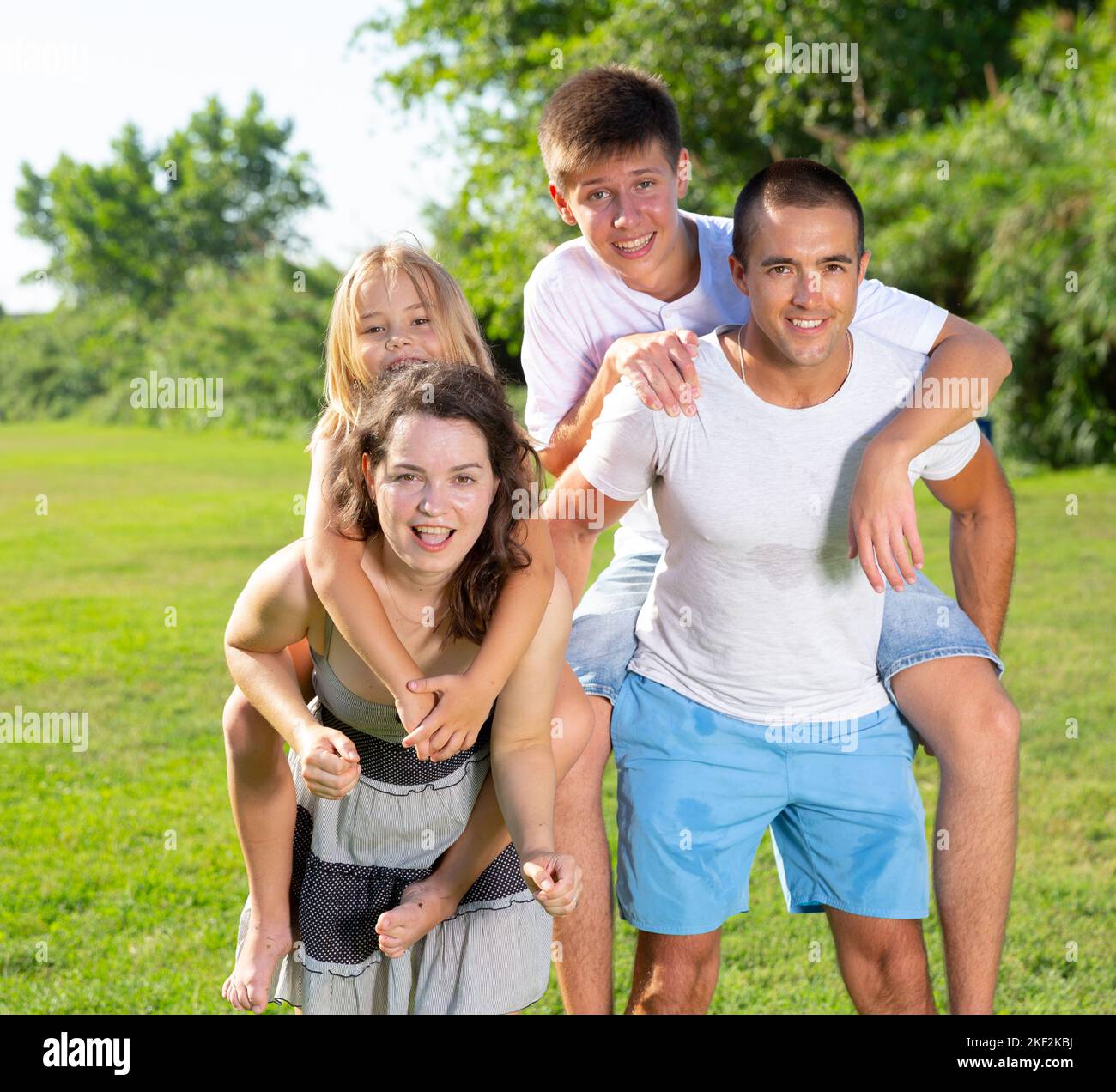 Famille de quatre personnes jouant dans le parc d'été Banque D'Images