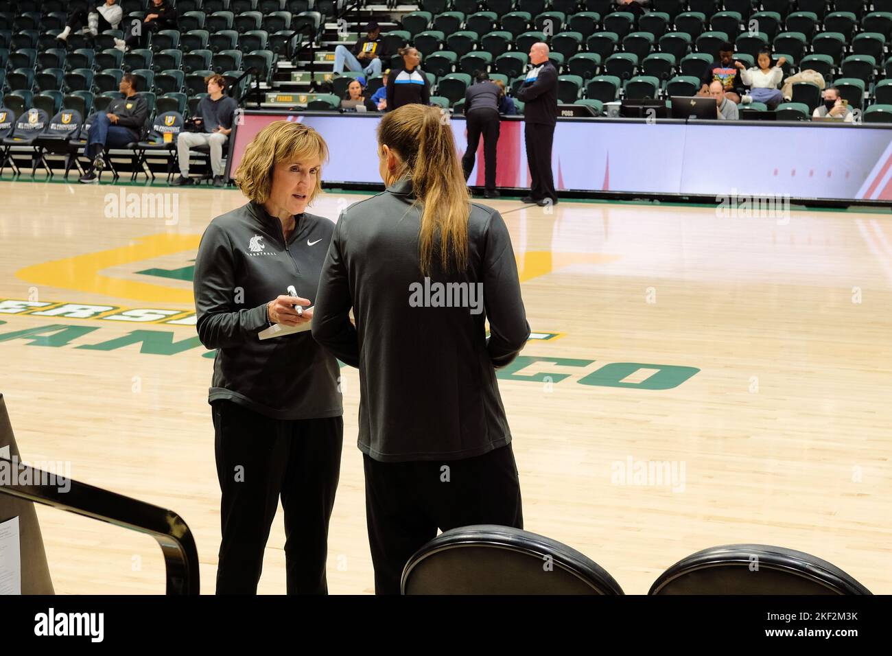 Kamie Ethridge, entraîneur-chef de basket-ball féminin de l'Université d'État de Washington, parlant avec un assistant avant un match contre l'Université de San Francisco. Banque D'Images