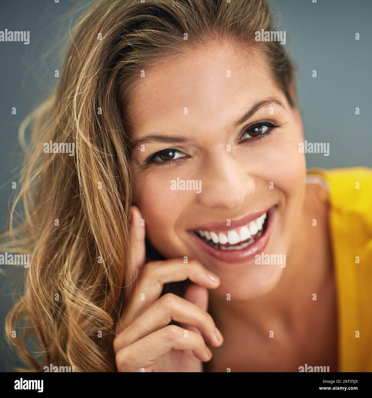 Soyez confiant dans qui vous êtes. Une jeune femme posant contre un mur gris. Banque D'Images