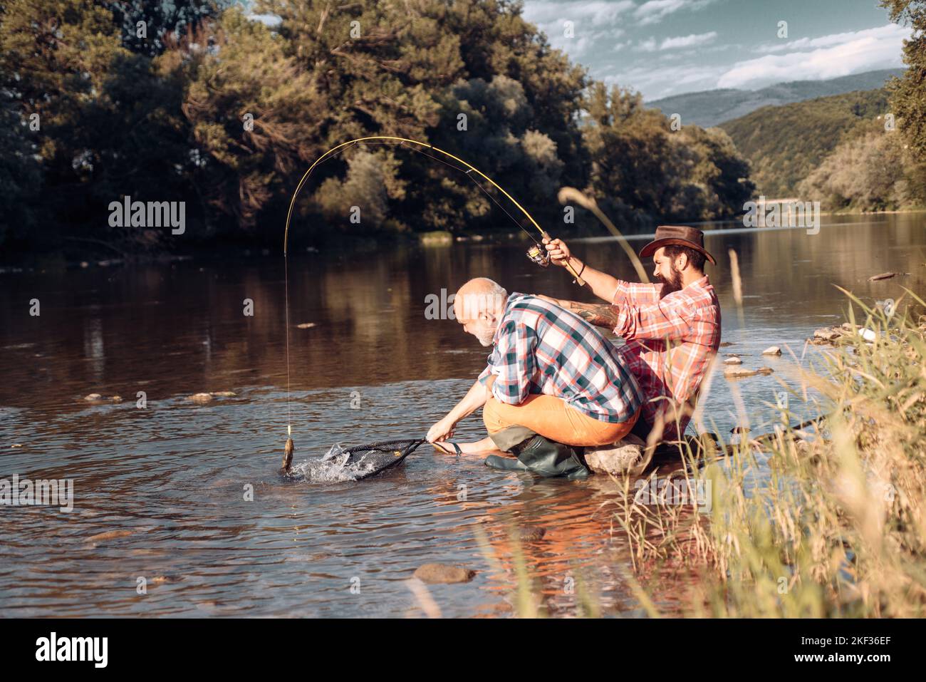 Pêcheurs hommes amis et truite trophée. Père et fils de pêche. Générations hommes pêche dans la rivière. Pêche à la truite. Banque D'Images