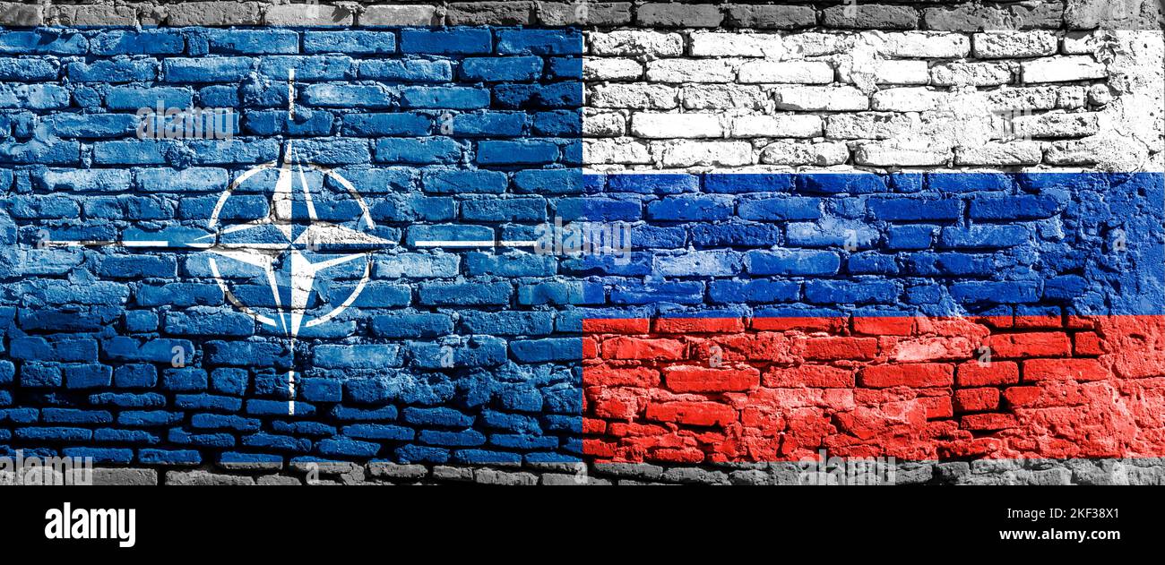 Les drapeaux de l'OTAN et de la Russie sur le mur avec une grosse fissure au milieu. Relations entre l'Organisation du Traité de l'Atlantique Nord et Banque D'Images