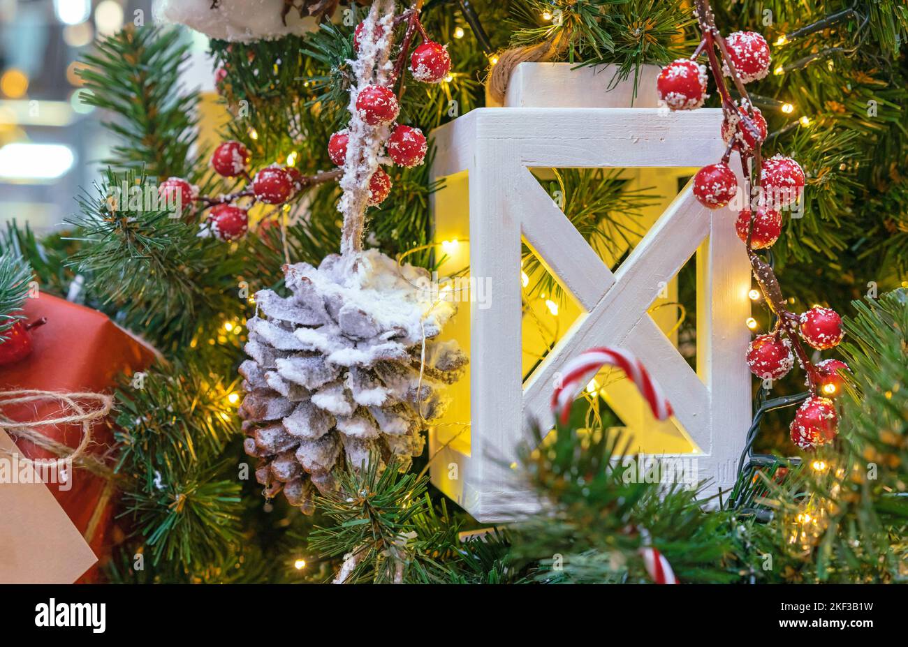Lanterne en bois blanc avec guirlande sur un arbre de Noël. Banque D'Images