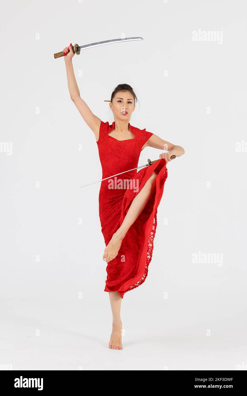 Aikido maître femme en robe rouge avec épée, katana sur fond blanc. Mode de vie sain et concept sportif. Banque D'Images