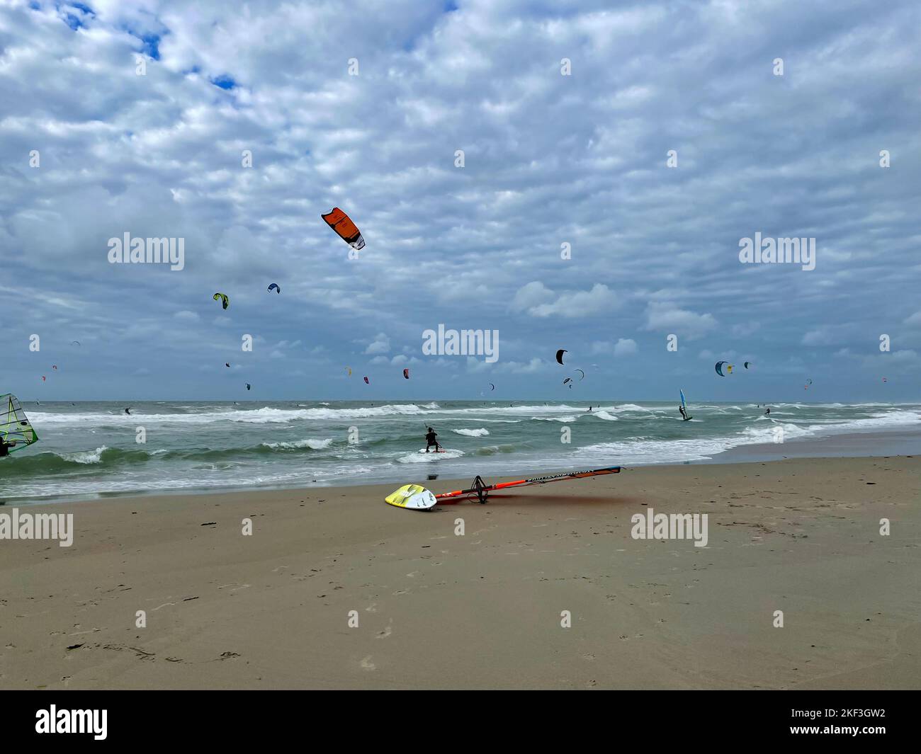 Surfeur et Kite surfer sur une journée venteuse et ensoleillée à la plage de la mer du Nord Banque D'Images
