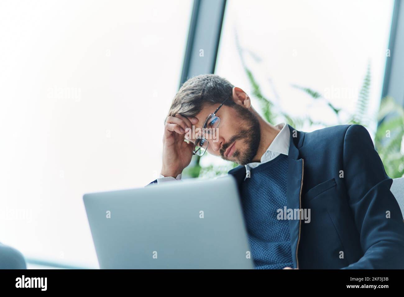 homme d'affaires attentionné avec un ordinateur portable dans la salle d'attente de l'aéroport. Banque D'Images