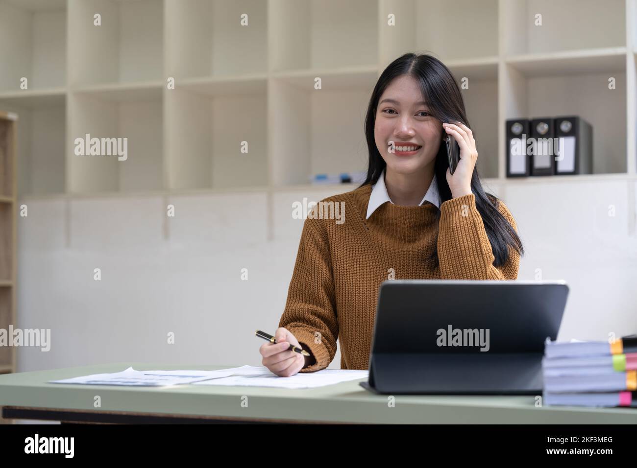 Portrait jeune femme d'affaires asiatique beau charmant souriant et parlant sur le téléphone mobile dans le bureau. Banque D'Images