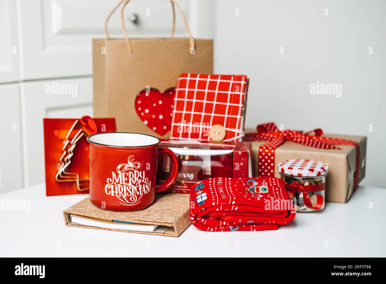 Noël boîte cadeau idées pour maman, mère, femme, elle. Accessoires de cuisson à zéro déchet femelle rouge et marron, tasse, chaussettes, cosmétiques, bloc-notes, bonbons Banque D'Images
