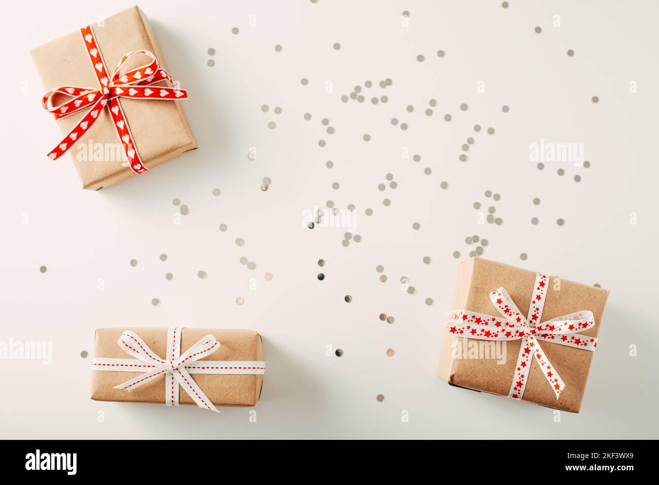 Trois boîtes-cadeaux sur fond blanc avec confettis. Espace de copie de la mise à plat Banque D'Images
