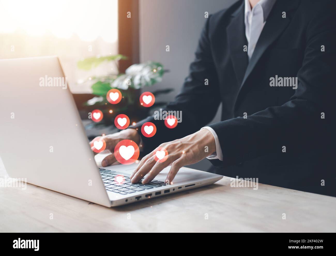 Chat et notification sur ordinateur portable avec coeur rouge emoji icône de médias sociaux. Homme d'affaires dactylographiant portable en vacances avec hologramme. Médias sociaux et d Banque D'Images