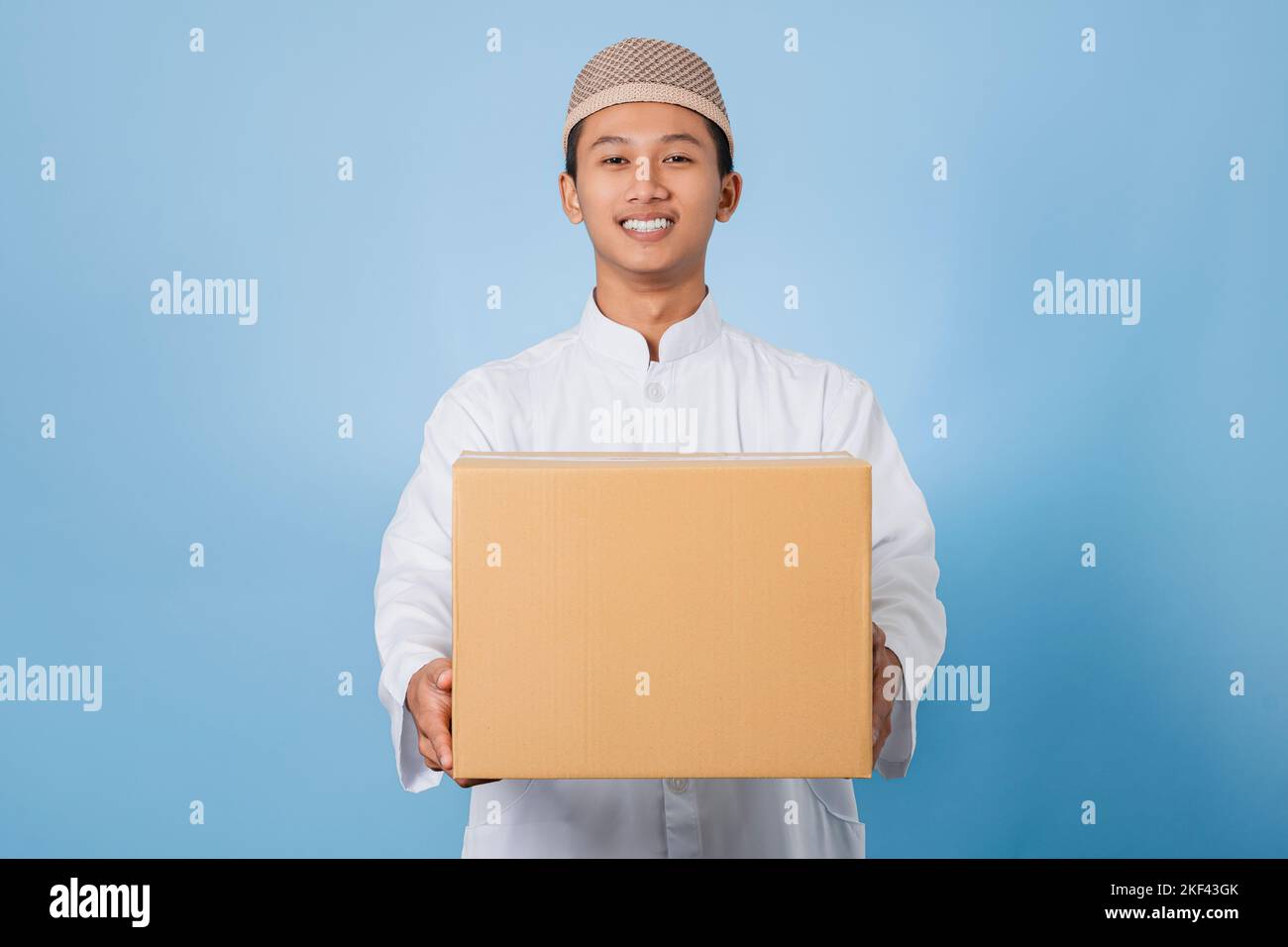 Souriant homme musulman asiatique heureux de célébrer Eid Al-Fitr isolé fond blanc. Célébrez le mois Saint du Ramadan dans l'Islam Banque D'Images