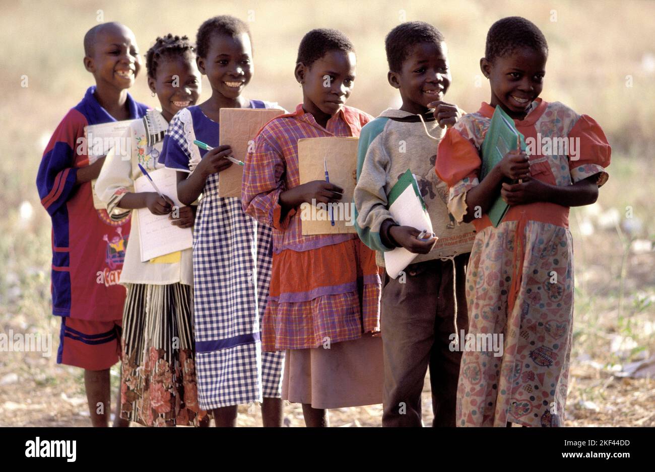 Burkina Faso, Fada; écoliers avec des carnets debout à l'extérieur. Banque D'Images