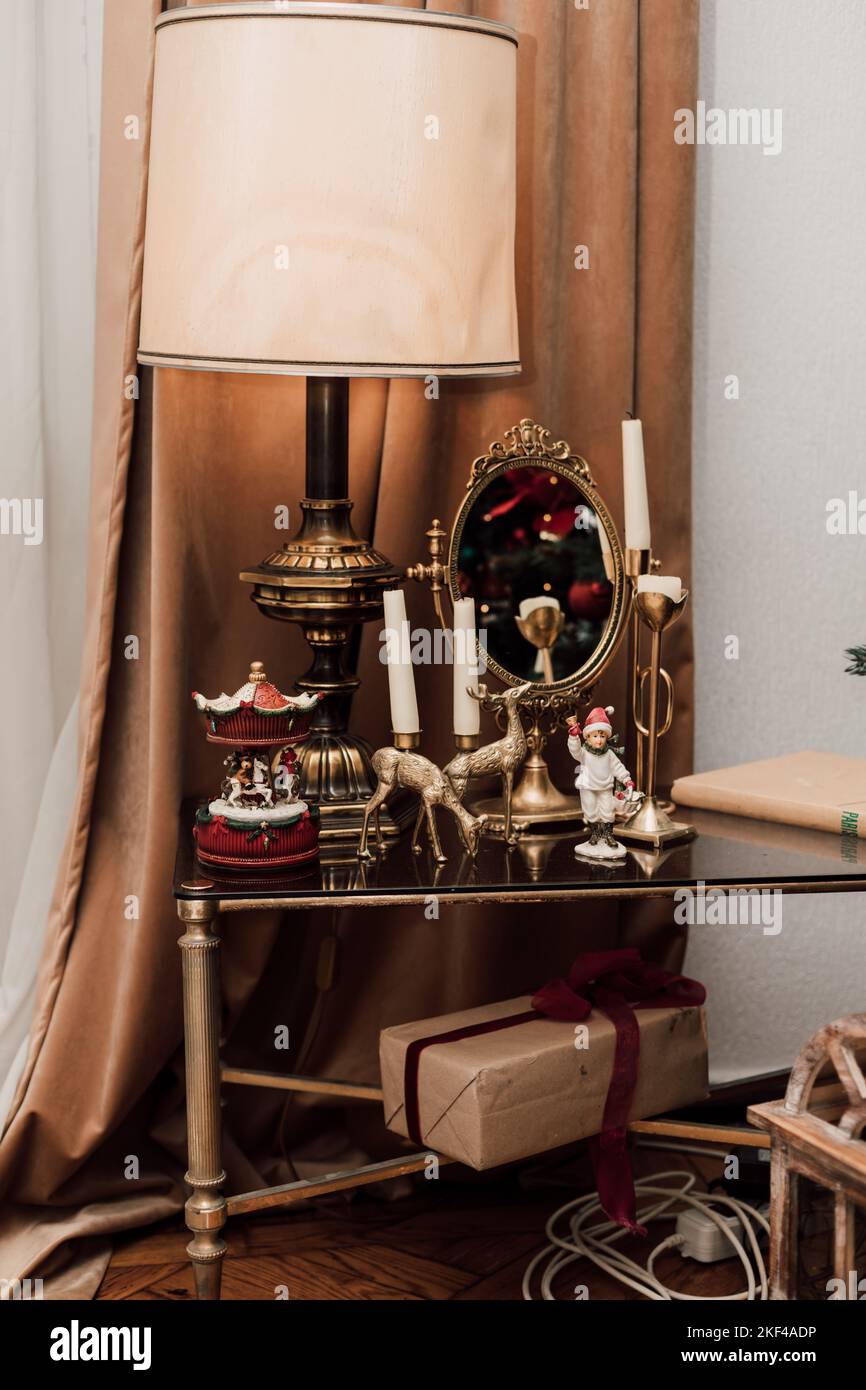 Table en verre avec lampe, chandeliers et petit miroir près de la fenêtre Banque D'Images