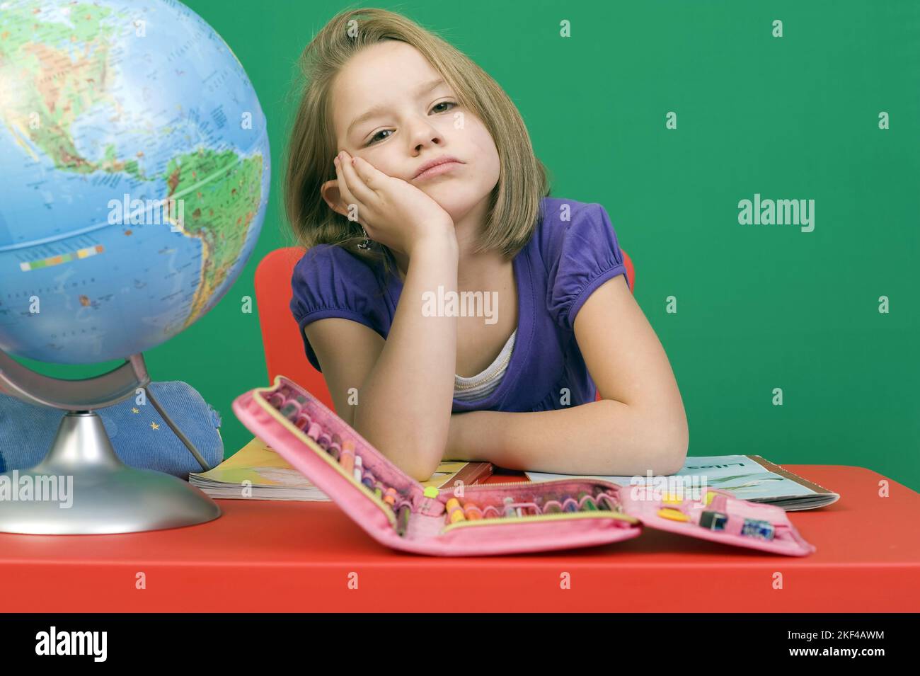 Sechsjähriges blonds Mädchen sitz gelangweilt in der Schule, Lernfaul, gleichgültig, Banque D'Images