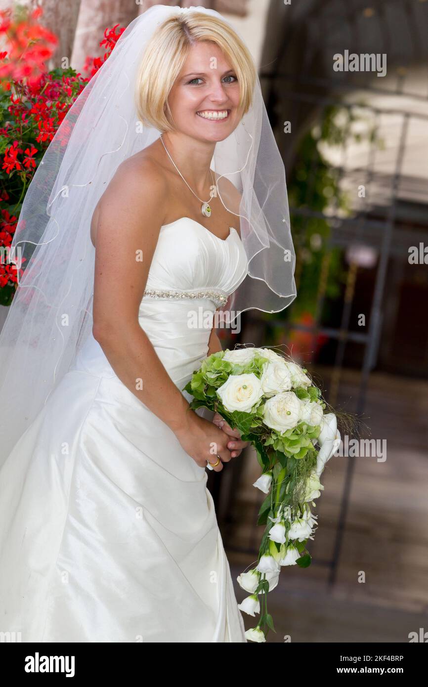 Eine fröhliche blonde Braut mit Brautstrauss, 30, 35, Jahre, Blond, Blondine, Banque D'Images