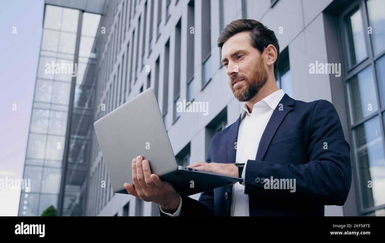 Homme d'affaires créateur réussi dactylographiant sur ordinateur portable crée un nouveau plan d'affaires de démarrage homme concentré travaillant à l'extérieur en utilisant l'ordinateur Banque D'Images