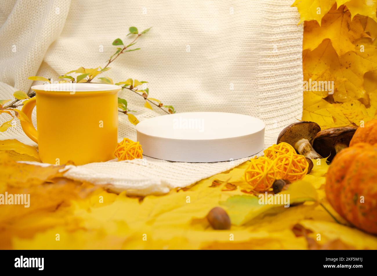 L'automne encore vie dans les tons jaune-orange: Un blanc tricoté plaid et des feuilles, gros plan vide podium scène blanche Banque D'Images