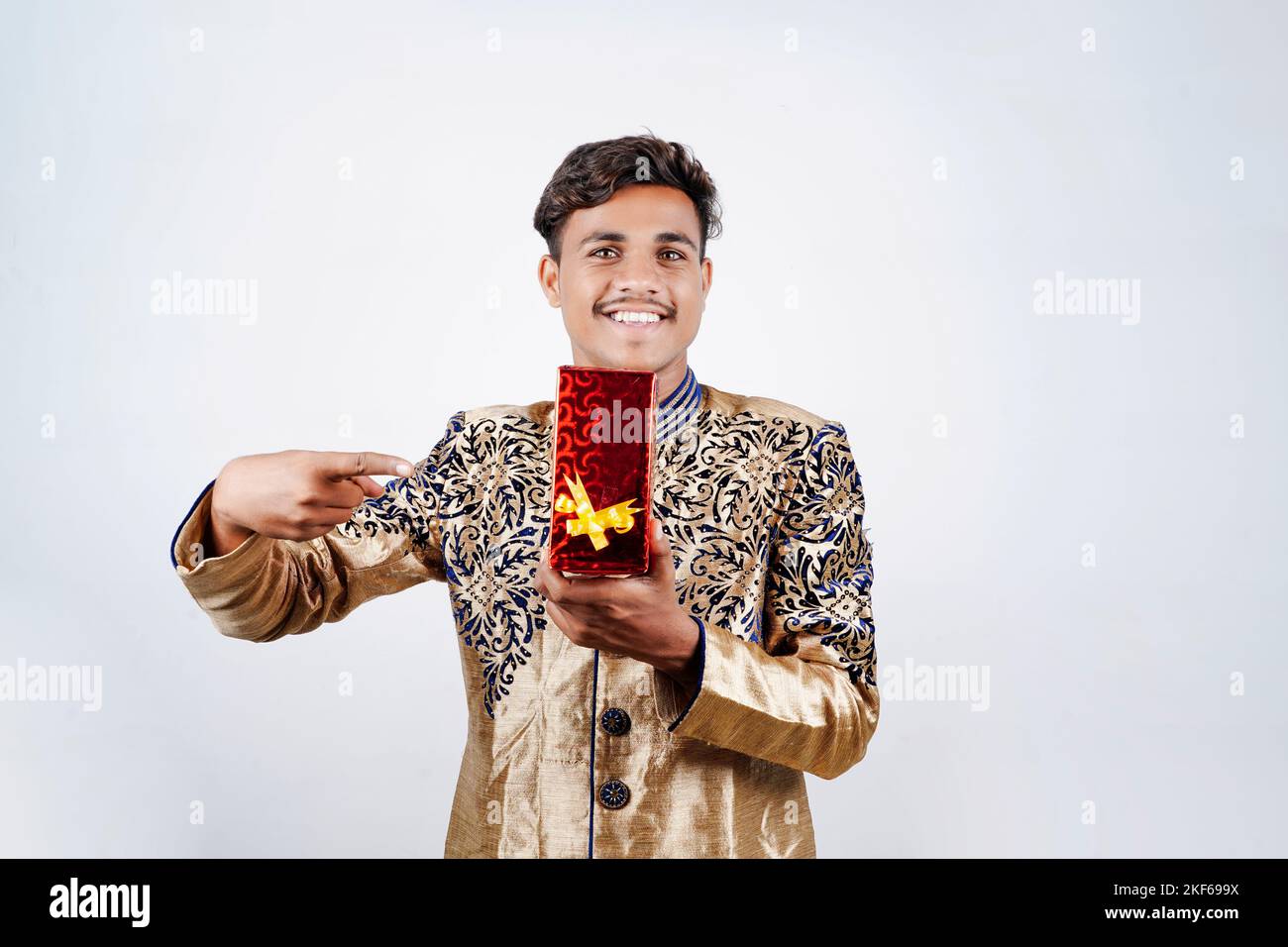 L'homme indien dans l'usure ethniques et Holding gift box à la main , isolé sur fond blanc Banque D'Images