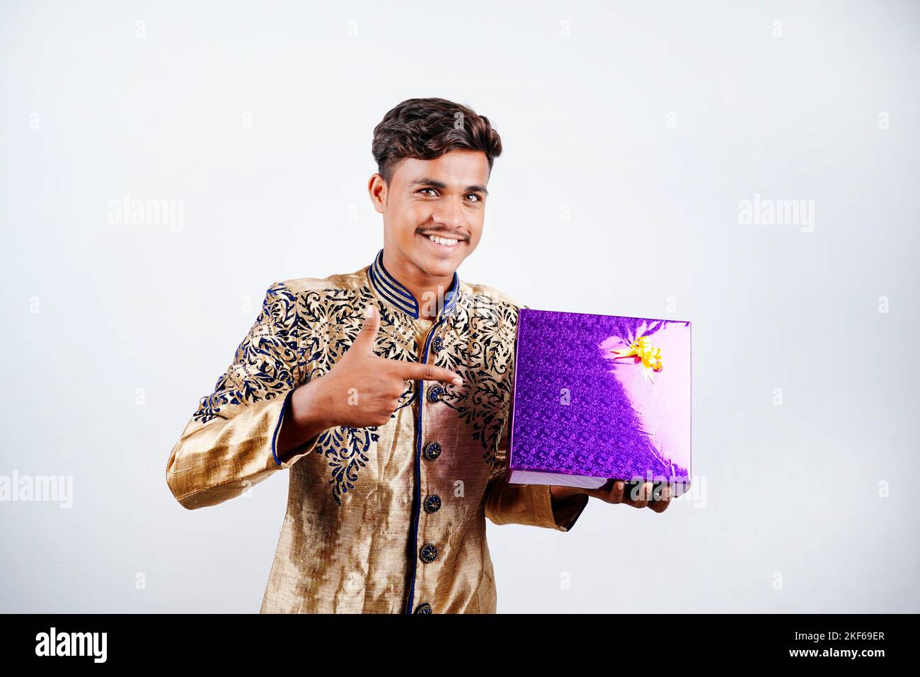 L'homme indien dans l'usure ethniques et Holding gift box à la main , isolé sur fond blanc Banque D'Images