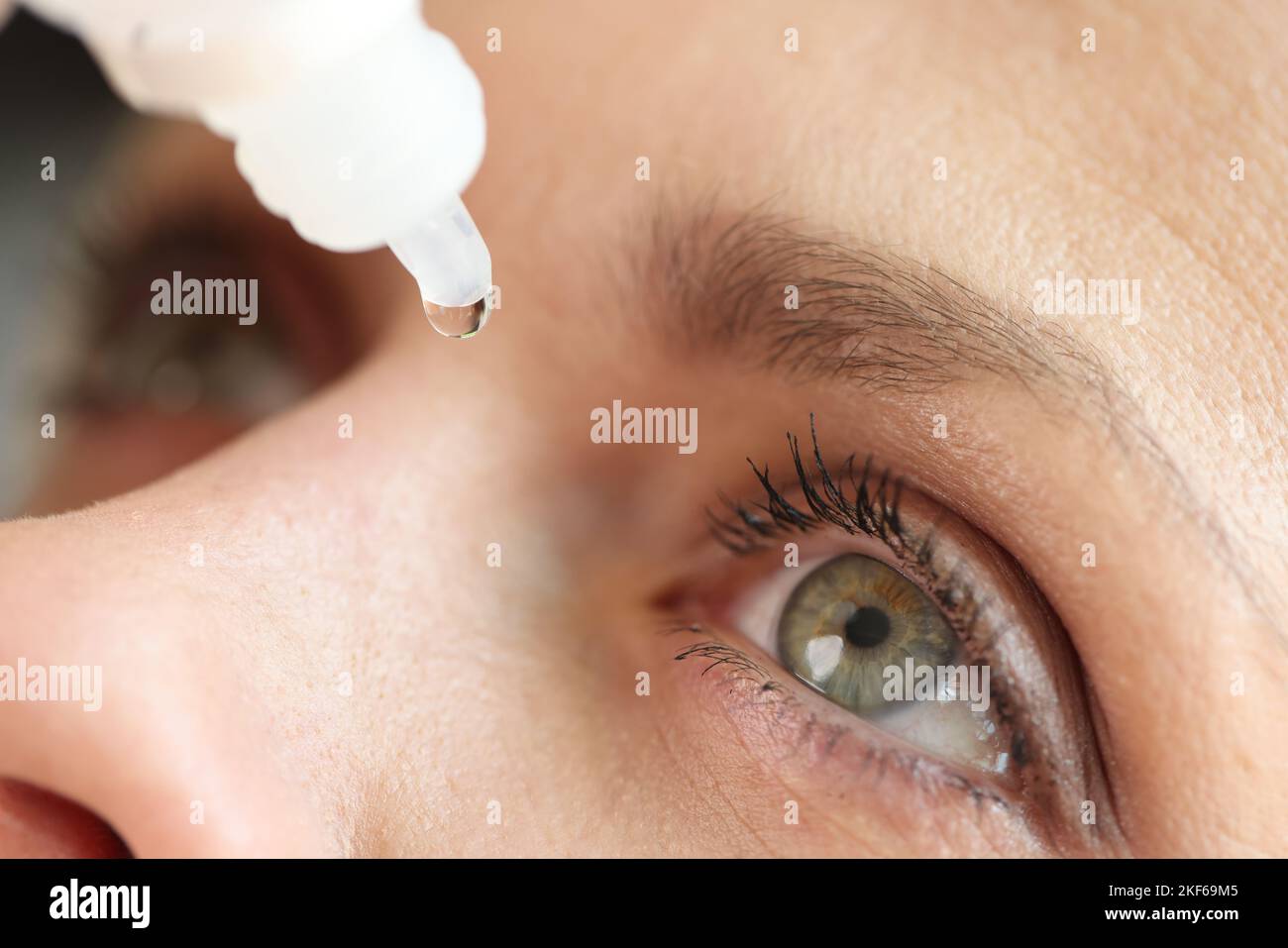 Femme caucasienne utilisant des gouttes médicales et des gouttes oculaires gros plan. Banque D'Images