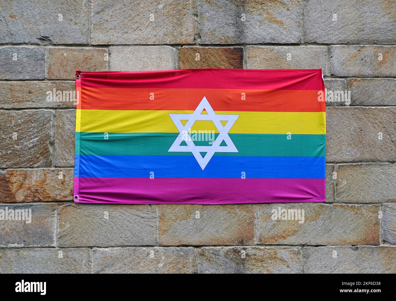 Drapeau arc-en-ciel de fierté gay avec Star of David, attaché à un mur de pierre Banque D'Images