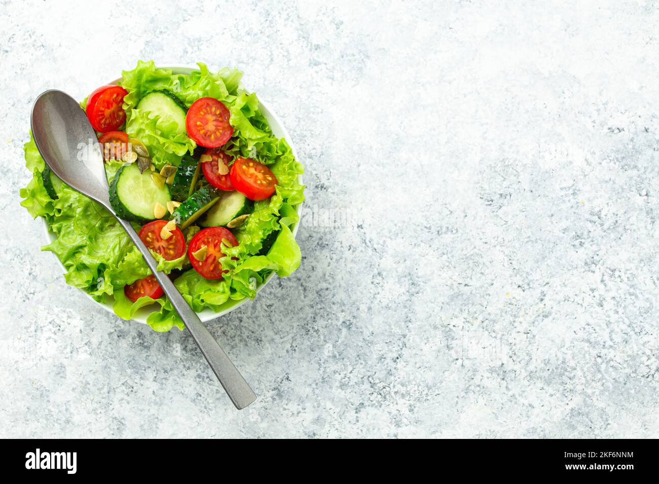 Tomates saines concombres iceberg laisse la salade sur table blanche vue du dessus Banque D'Images