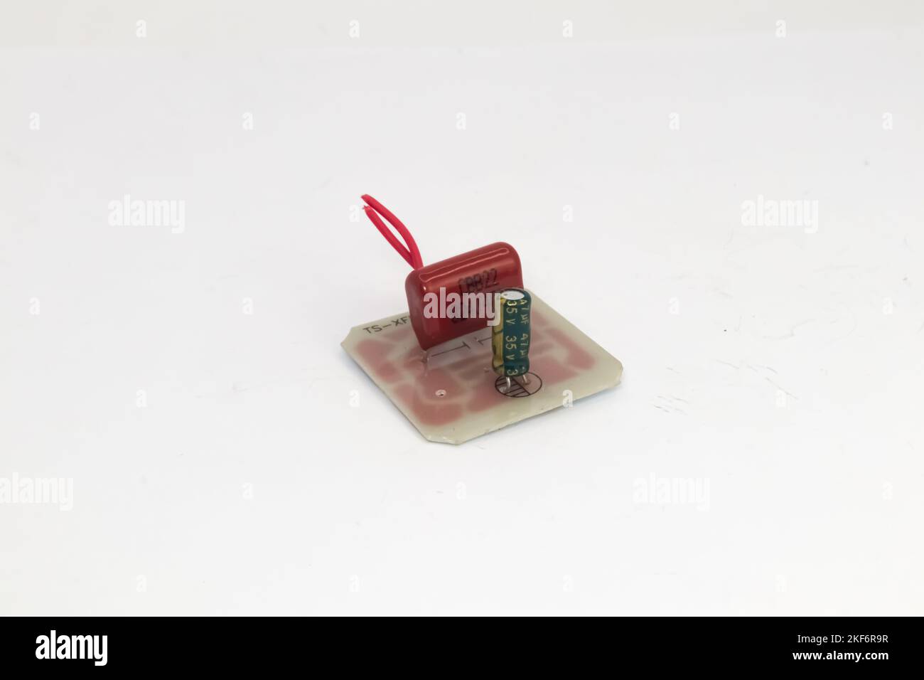 Un circuit imprimé avec deux condensateurs avec un fil rouge. Banque D'Images