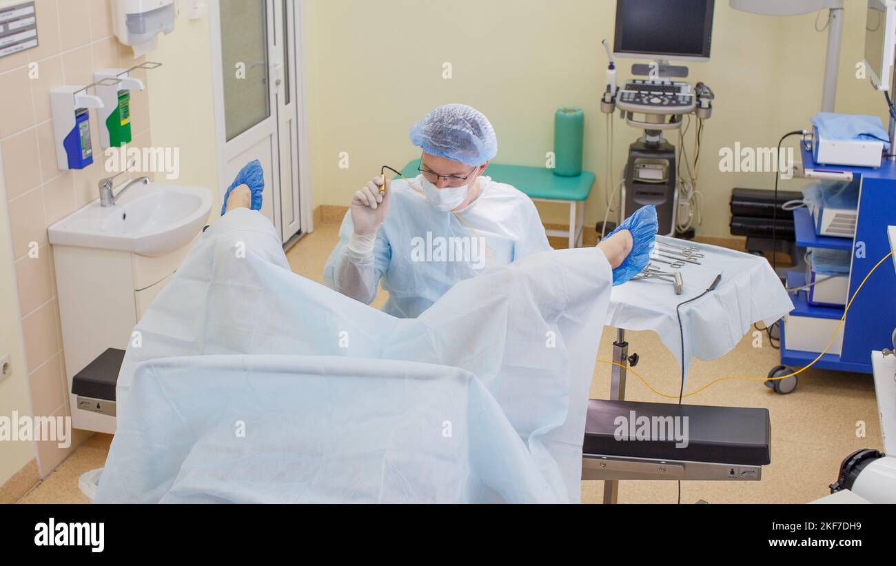 le proctologue examine le patient sur une chaise proctologique au bureau à  l'aide d'un équipement laser Photo Stock - Alamy