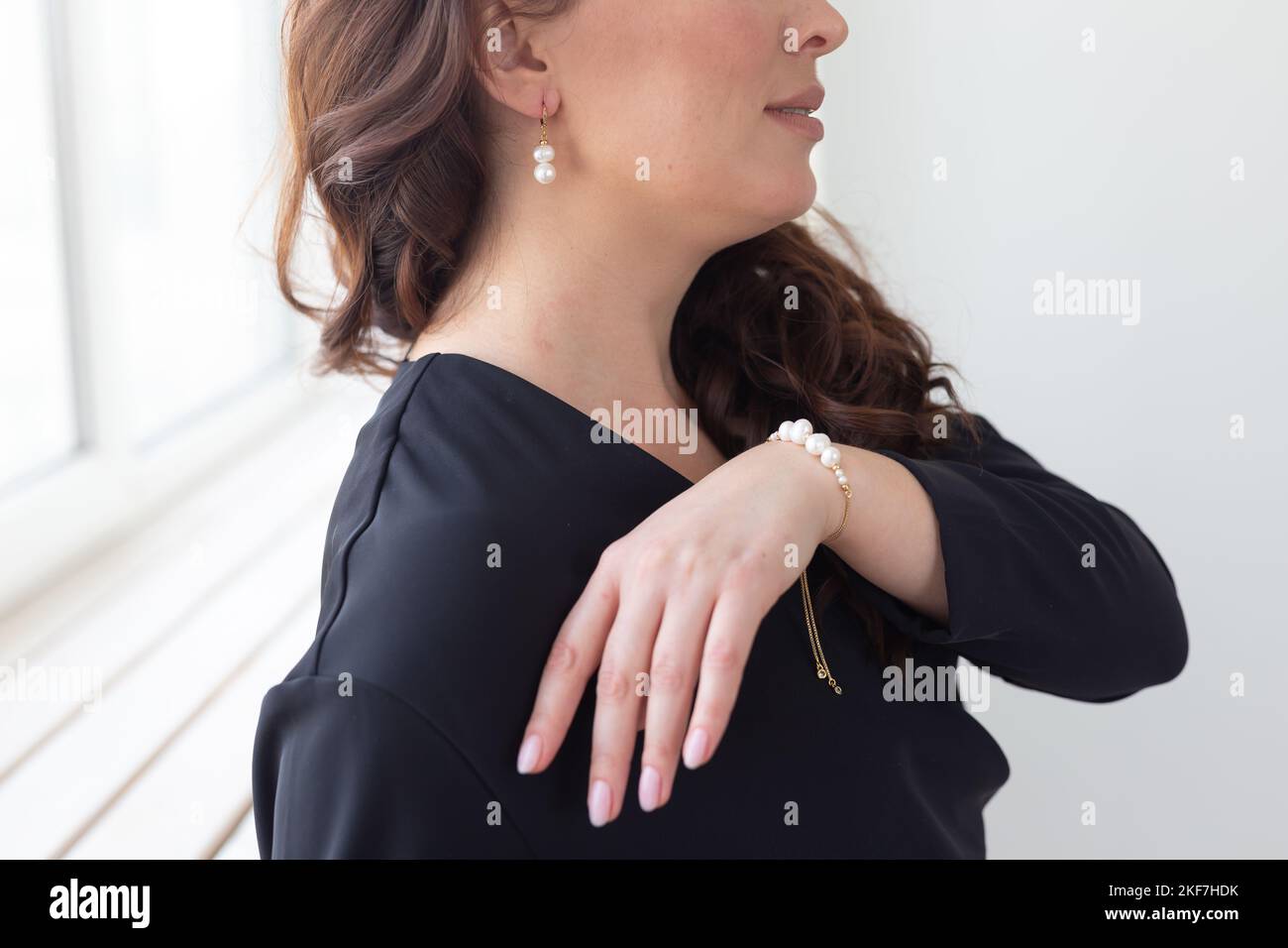 Gros plan d'une femme portant un bracelet en perles et des boucles d'oreilles. Concept bijoux, vêtements et accessoires Banque D'Images
