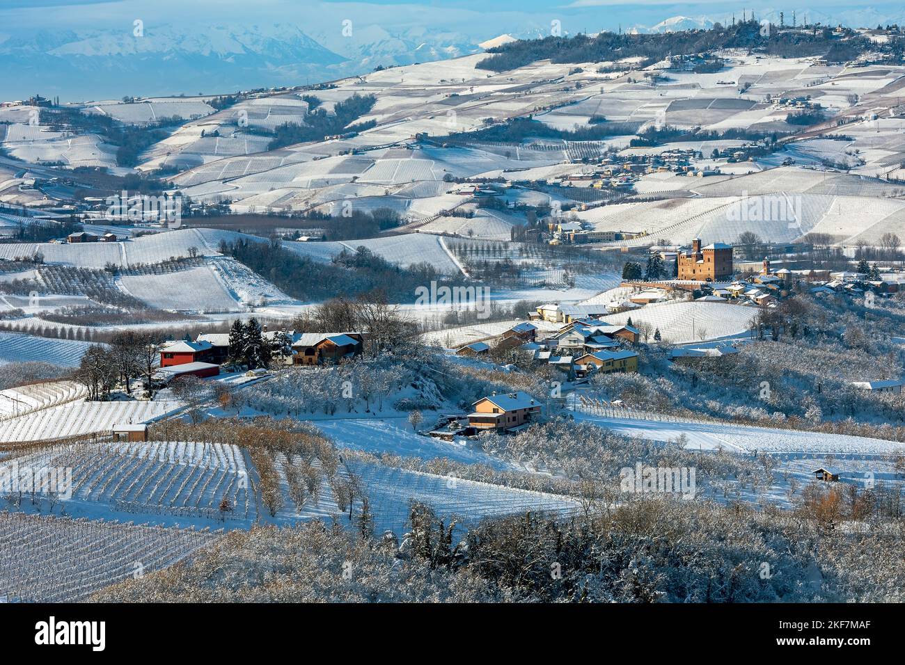 Vue sur le petit village au milieu des collines et des vignobles couverts de neige dans le Piémont, dans le nord de l'Italie. Banque D'Images