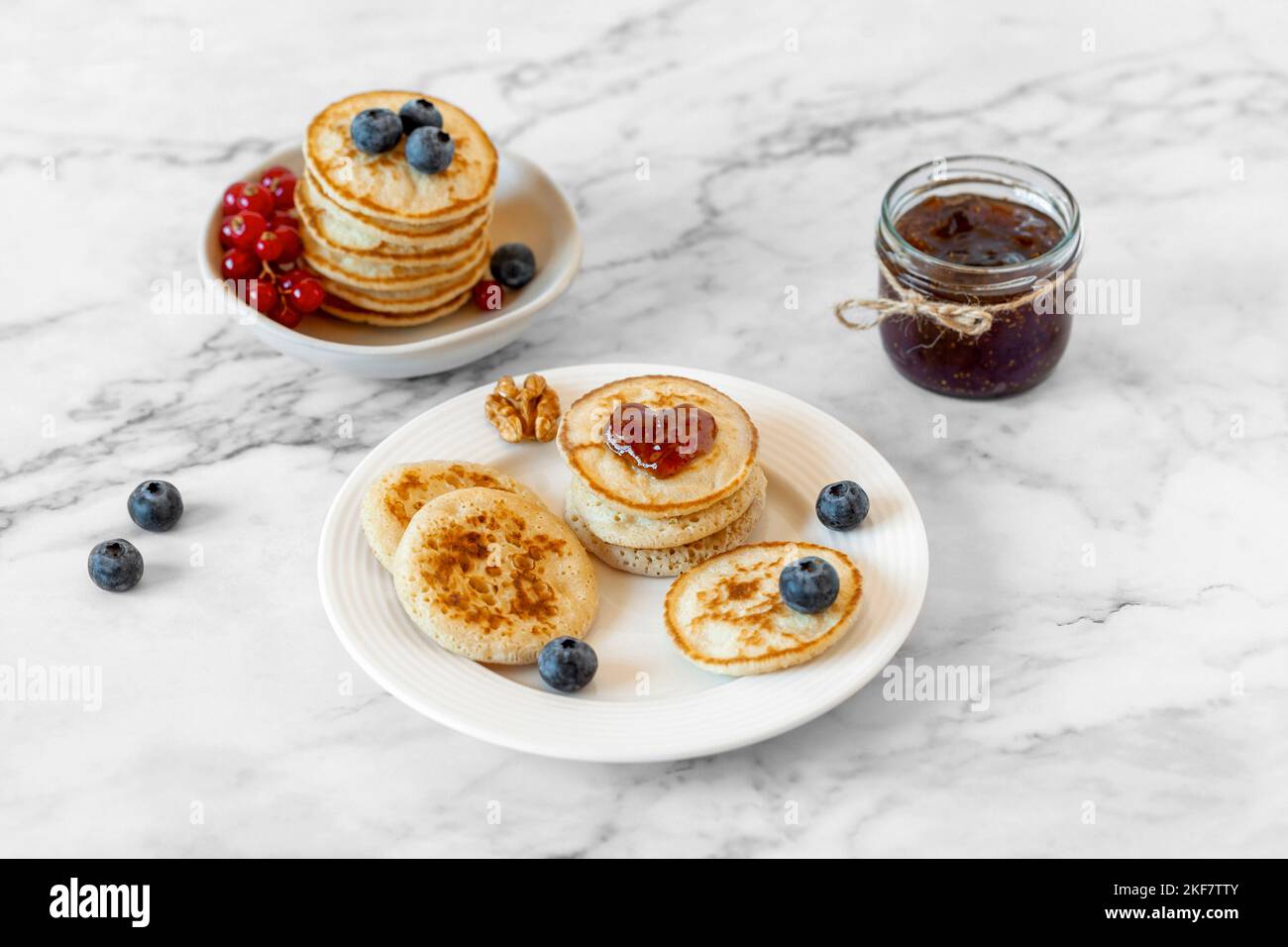 Petites crêpes décorées de confiture en forme de coeur et de baies fraîches, idée de Saint-Valentin Banque D'Images