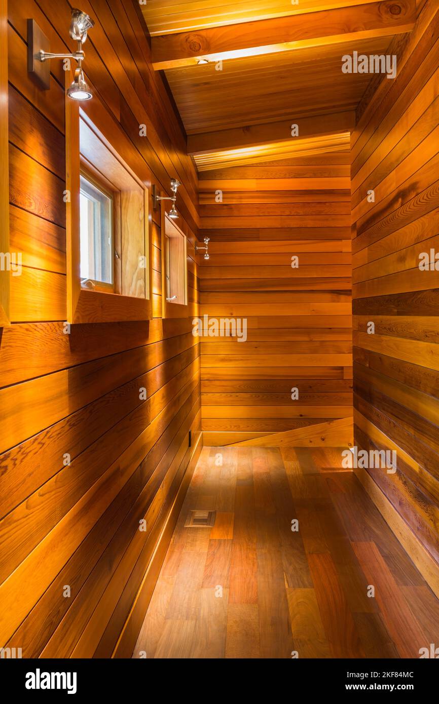 Couloir éclairé à l'étage avec murs en planches de cèdre au sol IPE et plafond à l'intérieur d'une luxueuse maison en cèdre teinté et en bois. Banque D'Images