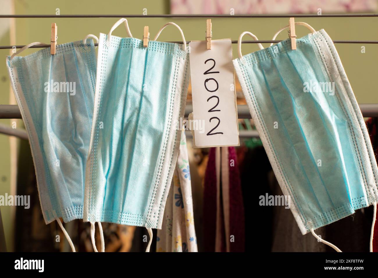 un masque médical accroché à une corde sur des épingles à linge à côté du texte 2022, la médecine dans la nouvelle année 2022 Banque D'Images
