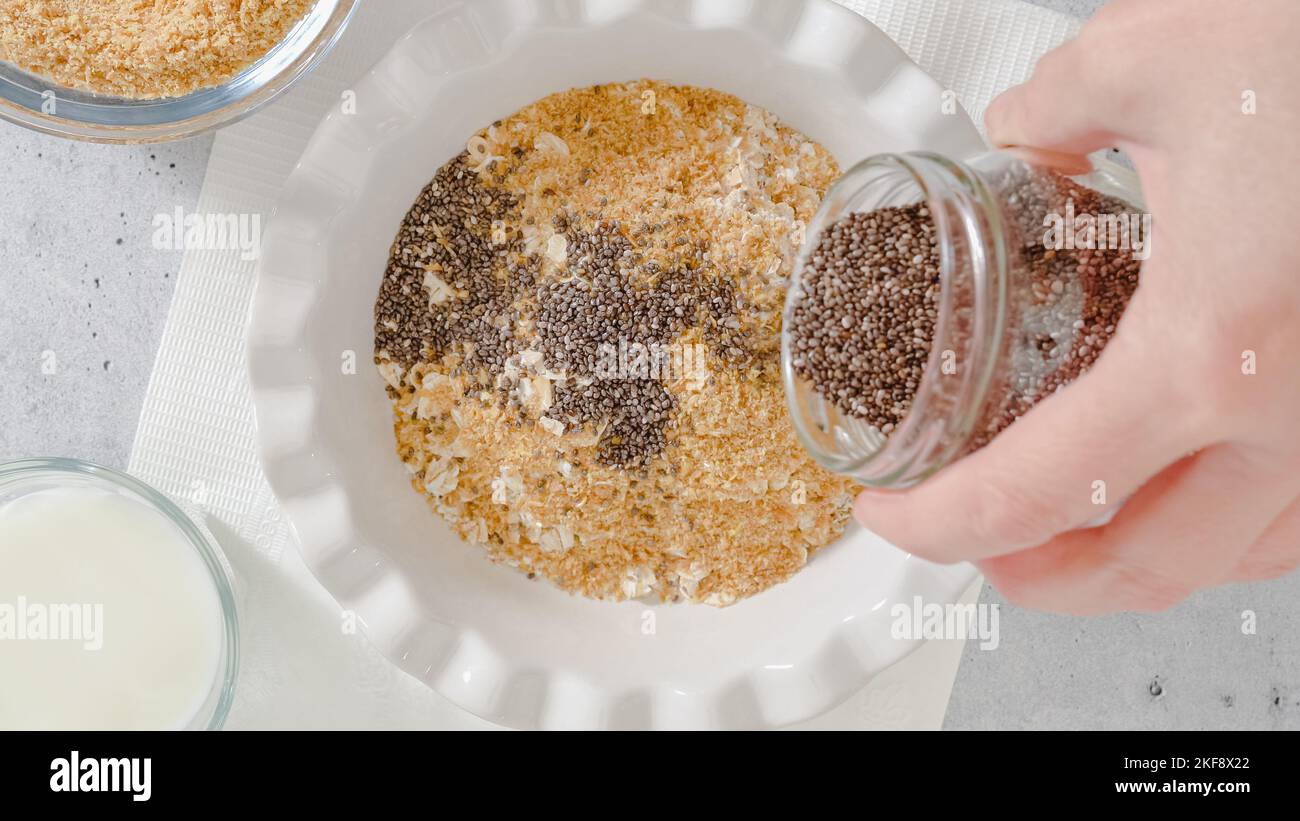 Femme préparant le petit déjeuner. Flocons d'avoine à base d'avoine entière, de farine de lin, de graines de Chia et de lait. Vue rapprochée du dessus Banque D'Images