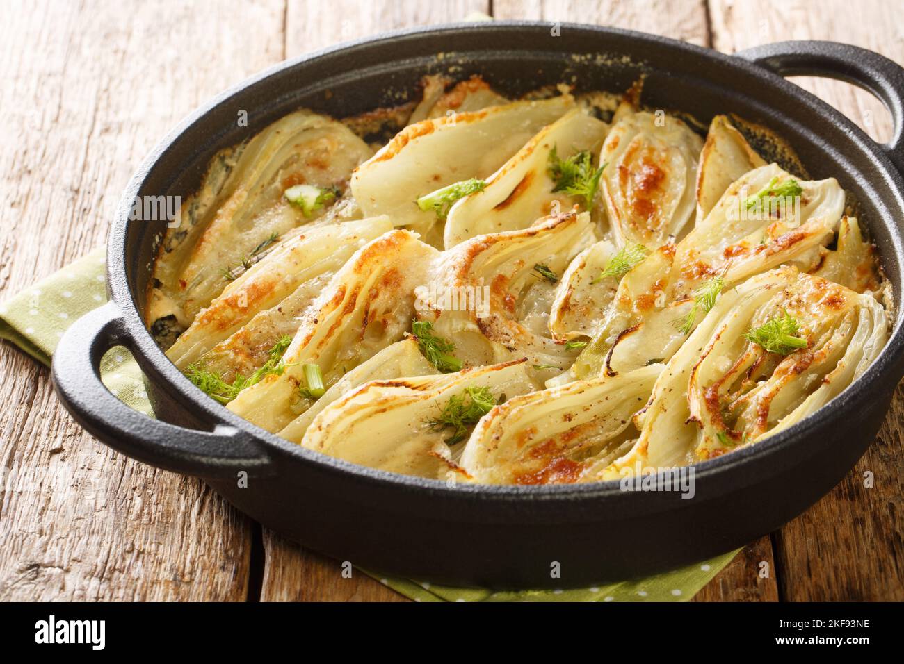 Gratin de fenouil maison à la guesy avec du parmesan sur la poêle sur la table en bois. Horizontale Banque D'Images