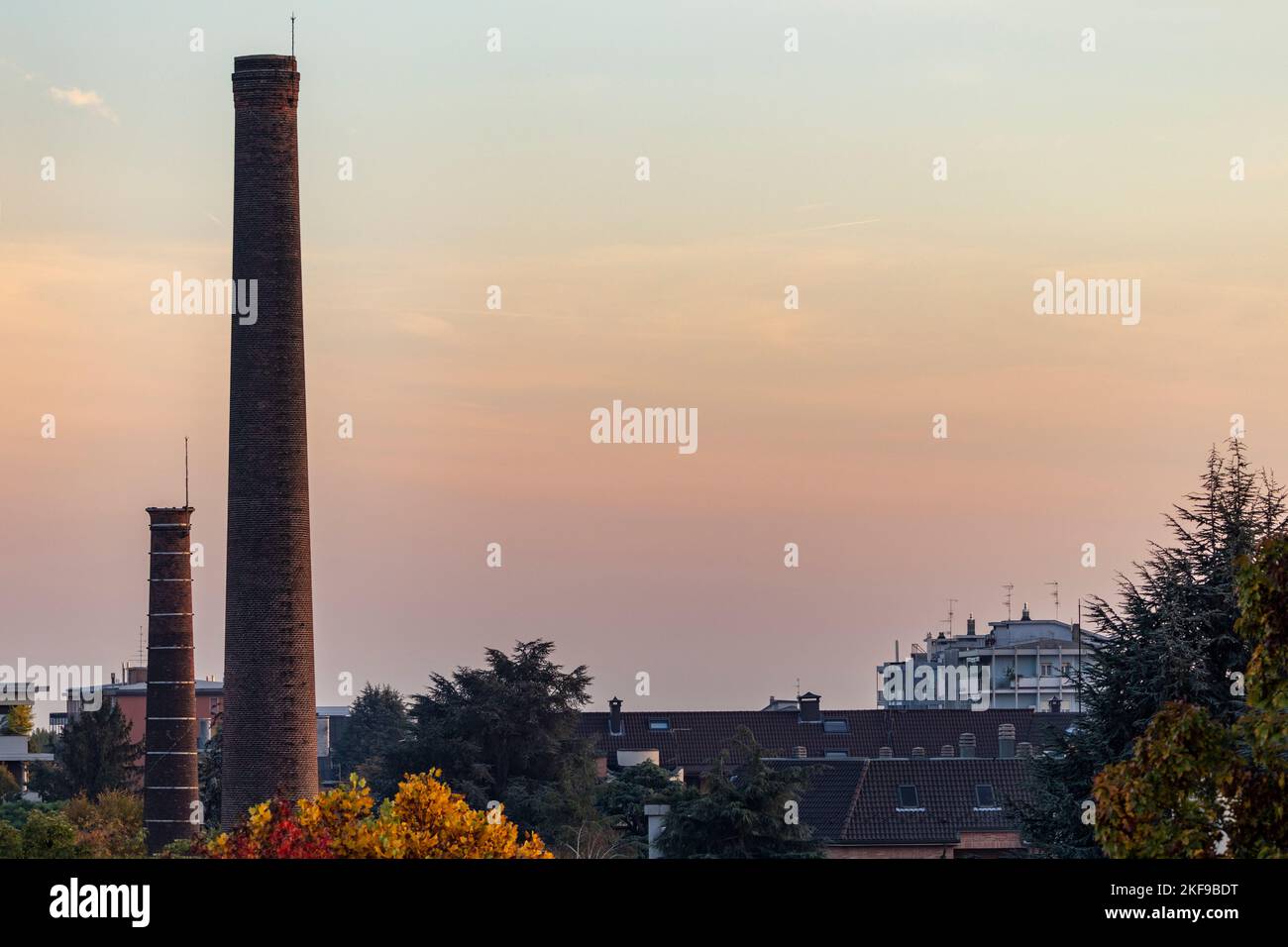 Deux cheminées rejetées au coucher du soleil à Busto Arsizio (Italie). En raison de son développement industriel, la ville a été connue "la ville de 100 cheminées Banque D'Images