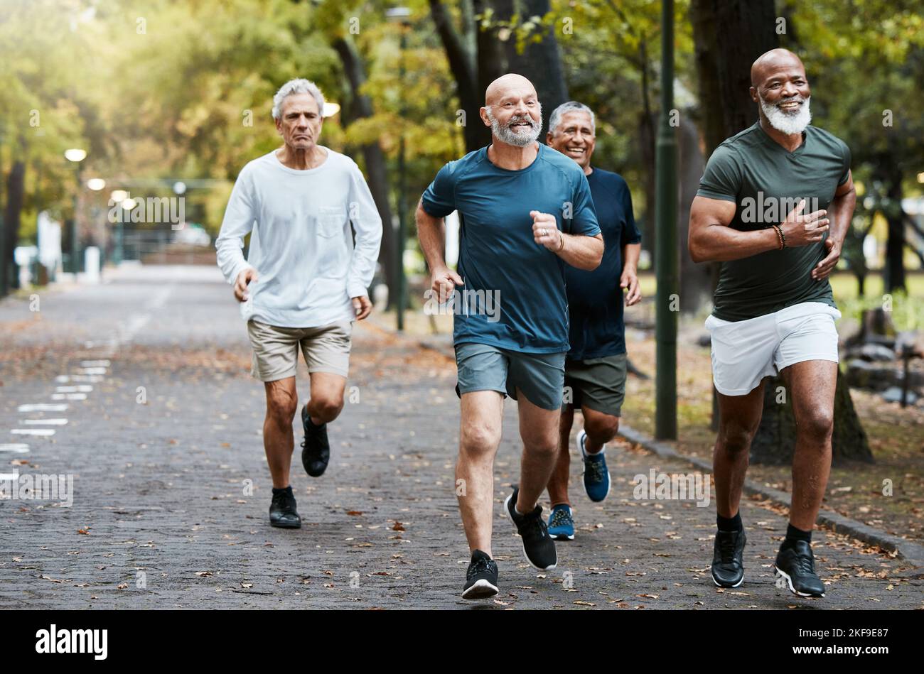 Senior, groupe d'hommes et courant dans la rue ensemble pour la remise en forme des personnes âgées et le bien-être urbain avec bonheur. Bonne retraite, sourire et club de coureurs à l'intérieur Banque D'Images
