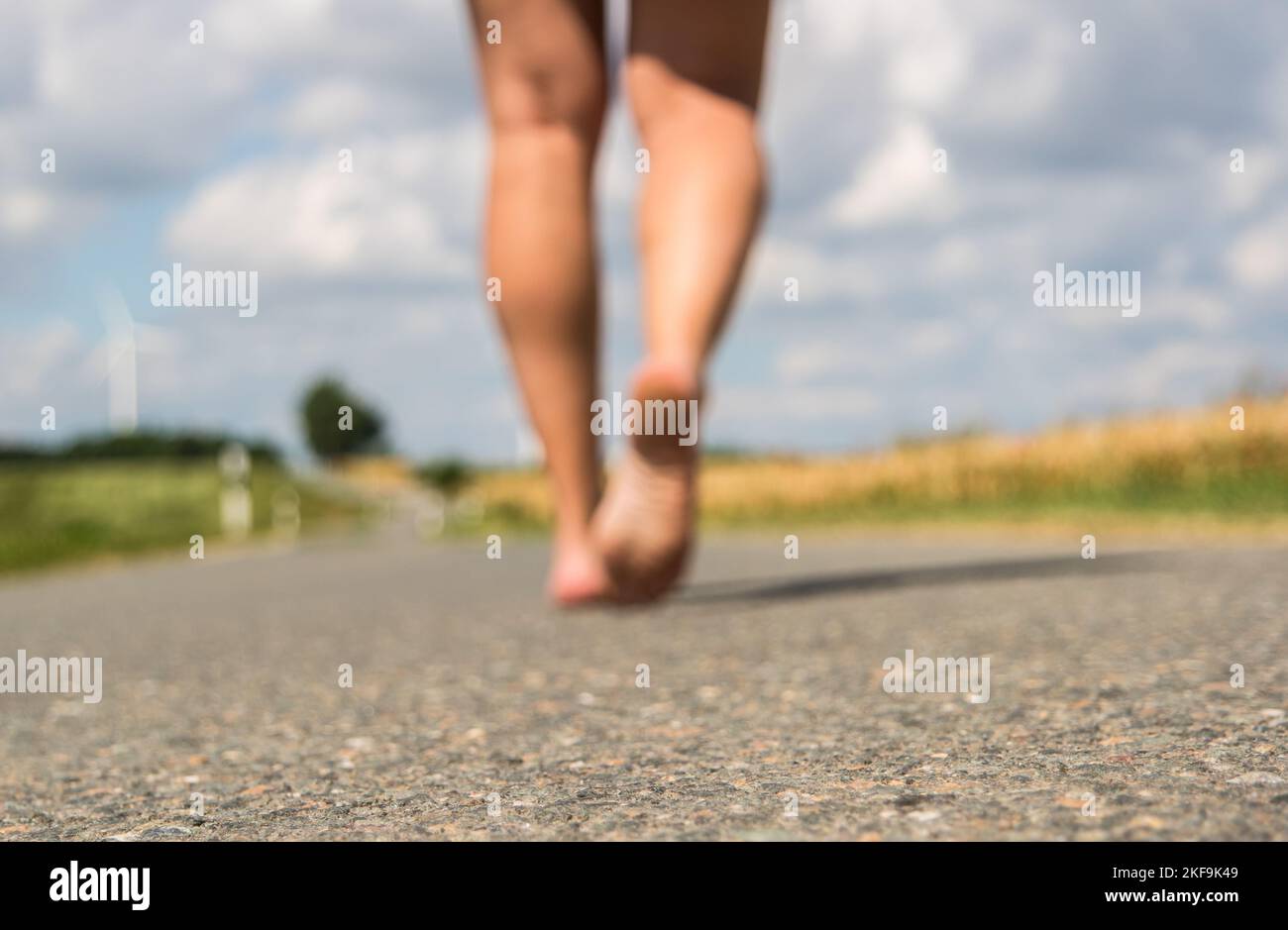 Jeune femme marchant pieds nus dans une rue Banque D'Images