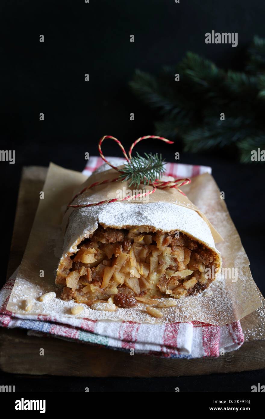 Strudel aux pommes maison avec pâte phyllo, cannelle, sultanines, pignons de pin sur fond rustique. Strudel aux pommes de Noël. Directement au-dessus. Banque D'Images