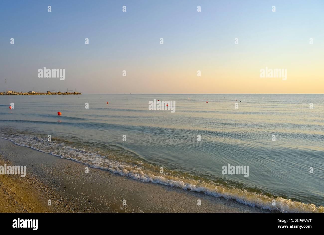 lever du soleil sur la plage de sable avec une ligne de bouées rouges. Littoral, ligne horizontale, arrière-plan naturel. Lever du soleil Banque D'Images