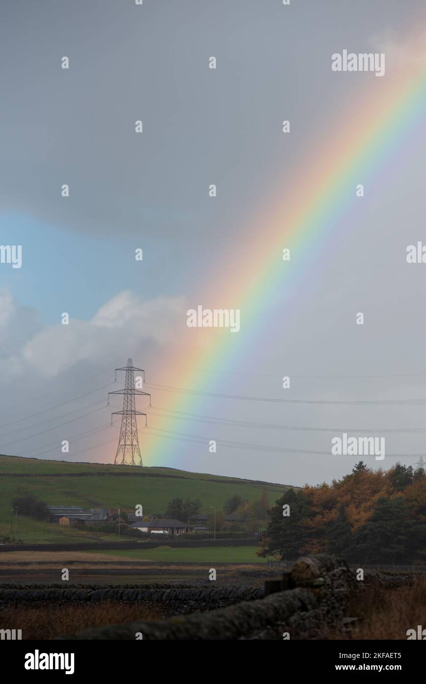 Pylône d'électricité avec arc-en-ciel à travers elle. Banque D'Images