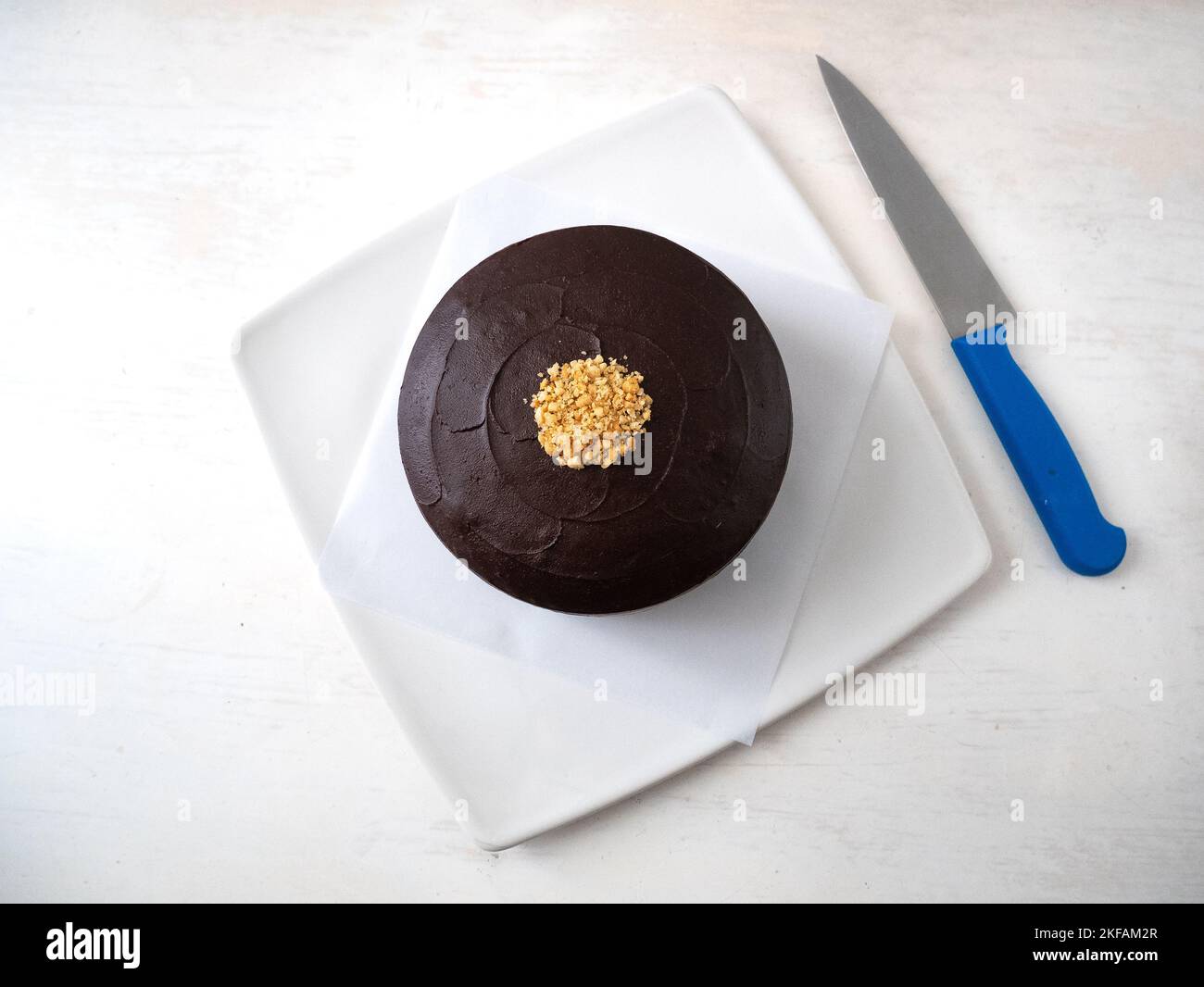 Gâteau au chocolat végétalien avec beurre de cacahuète, couvert de crème au  chocolat et décoré de petits morceaux de cacahuètes sur une table blanche à  côté d'une la Photo Stock - Alamy