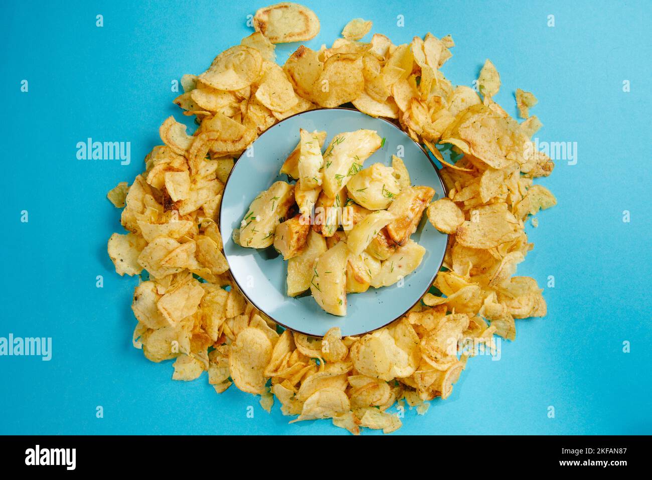 Aliments nocifs. Pommes de terre frites et frites sur fond bleu. Les aliments frits sont mauvais pour la santé Banque D'Images