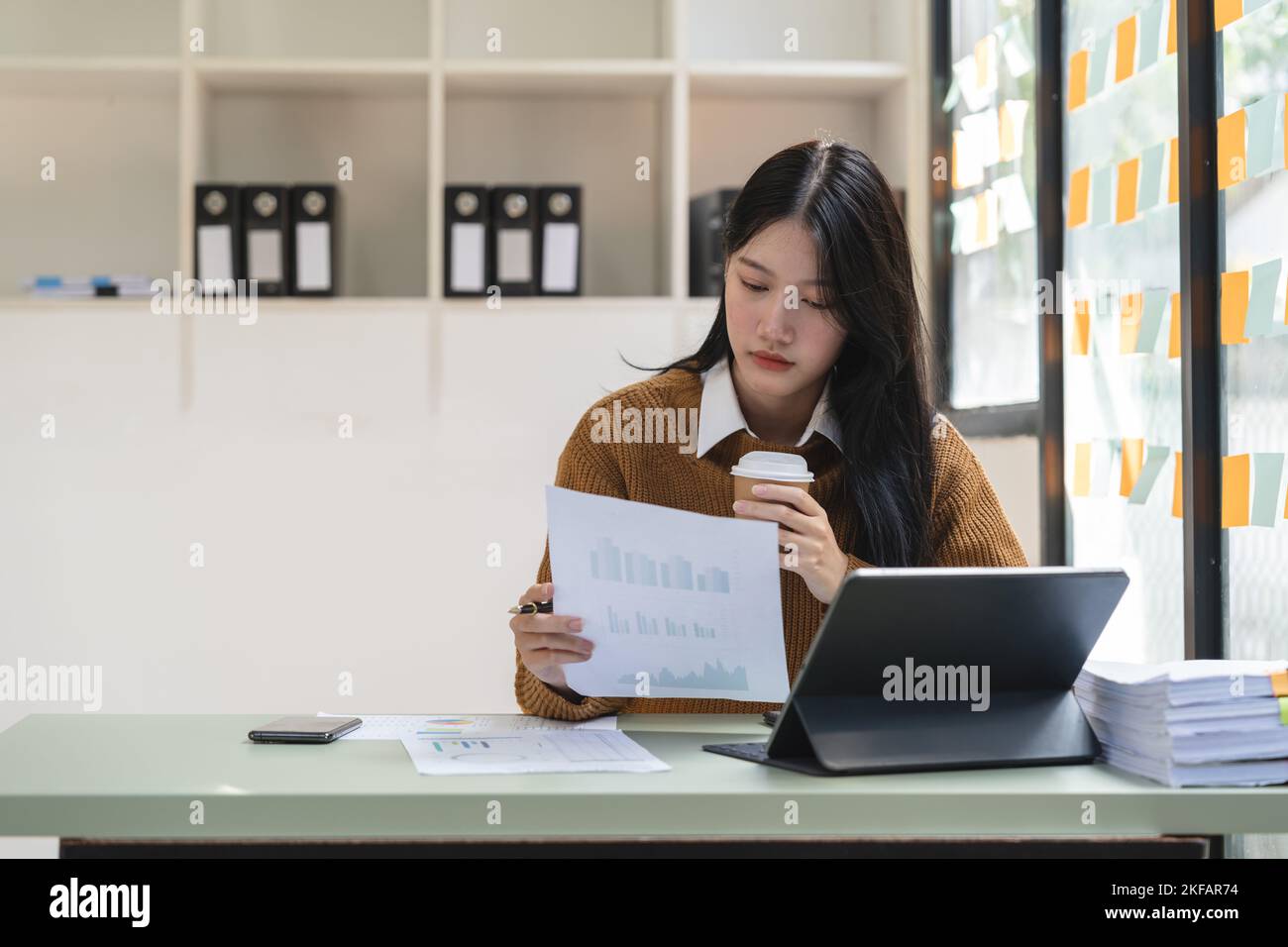 Jeune femme asiatique travaillant sérieusement sur ordinateur portable dans la maison.Elle pense trouver la solution problème de travail Banque D'Images
