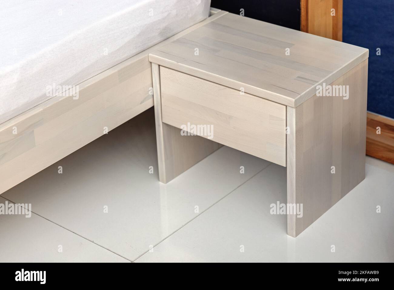 Table de nuit en bois blanc avec tiroir dans la chambre Banque D'Images