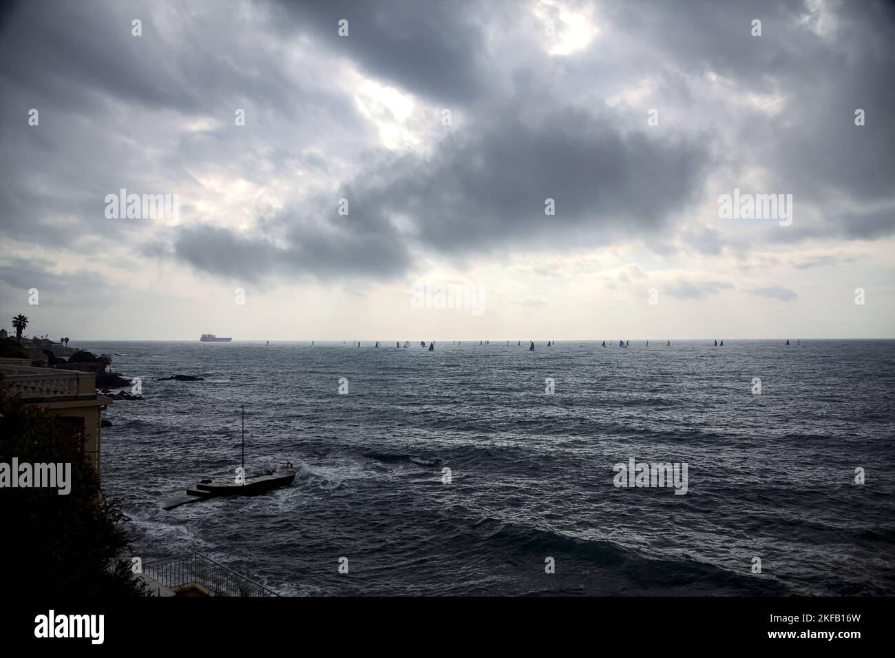 Bateau à voile et un bateau au loin par une journée nuageux Banque D'Images